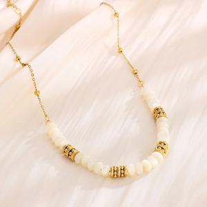 Elegant gold titanium steel necklace featuring white beads and textured gold accents