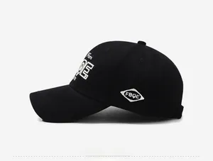 Side view of black cotton baseball cap showing white FBQE embroidery and twill fabric detail