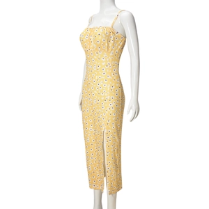 Dettaglio del vestito lungo giallo a fiori con spacco laterale alto e margherite