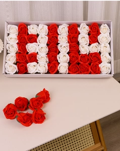 Detailed view of 50 red and white soap rose flower heads in a white gift box packaging