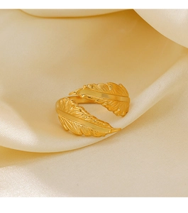 Detailed macro shot of a golden feather open ring with fine embossed texture on silk