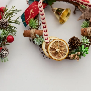 Mini Christmas wreath with pinecones red berries cinnamon sticks and golden bells