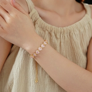 Close-up of heart-shaped pink zircon bracelet with gold adjustable drawstring chain