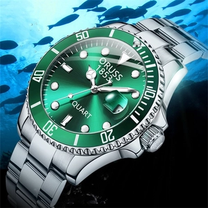 Detail of waterproof silver steel watch with green dial submerged in underwater fish scene