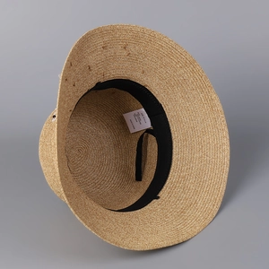 Detail of woven straw hat interior with black sweatband and size 57.5cm material label