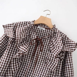 Women's brown checkered long sleeve shirt with ruffle trim and bow tie detail