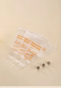 Detailed view of clear disposable pastry bags with orange size markings on a wooden tray
