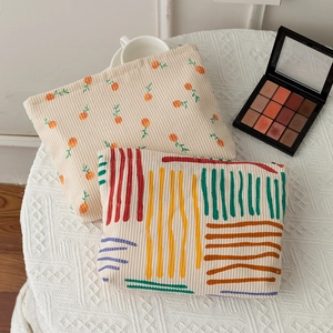 Detailed corduroy cosmetic bag with floral print and colorful abstract patterns