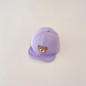 Detailed embroidery of a cute brown bear patch on a light purple soft cotton baby cap