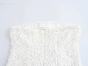 Gros plan du haut en dentelle blanche montrant le col intérieur et la fermeture éclair invisible
