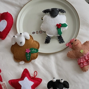 Detailed view of handmade Christmas wool felt ornaments with gingerbread man and stars
