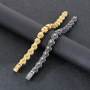 Close-up of retro punk skull link bracelets in gold and silver on black cylinder stand