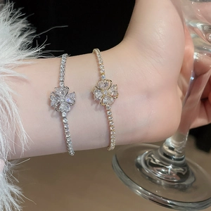 Close-up of sparkling zircon clover bracelets in gold and silver finish with pave setting