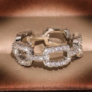 Macro shot of silver chain link ring with pavé-set cubic zirconia and geometric details
