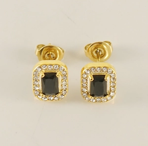 Macro view of gold stud earrings with rectangular black stone and white diamond halo