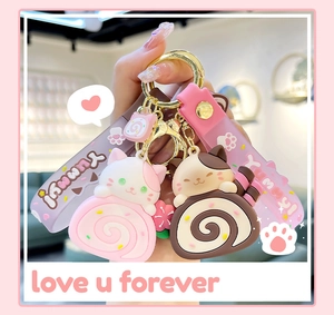 Detailed shot of cute cat cake roll silicone keychains held in hand for bag decor