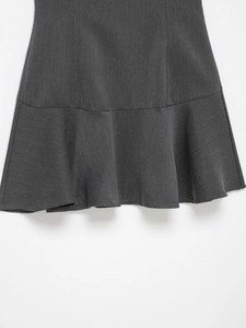 Gros plan sur les volants de la jupe gris anthracite et la texture du tissu sergé