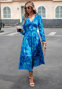 Women's blue printed V-neck maxi dress with long sleeves and ruffled hem on a city street