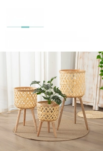 Close-up of hand-woven bamboo plant basket with three-legged solid wood stand