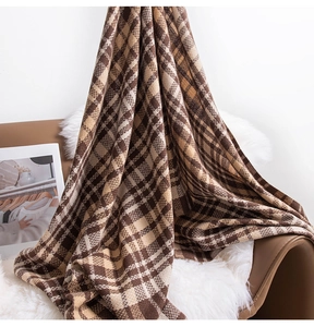 British style brown plaid scarf draped on a leather chair for cozy winter aesthetics