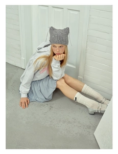 Detailed close-up of grey knit cat ear beanie with handmade crochet texture and ties
