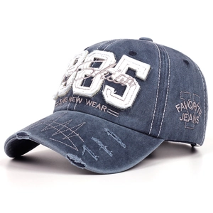 Detail showing the 1985 patch embroidery and distressed frayed edges on a vintage cotton cap