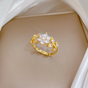Macro detail of gold flower ring with sparkling zircon stones and leaf texture