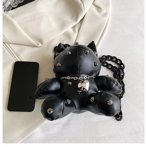 Detail of black teddy bear crossbody bag with silver studs and chunky chain strap
