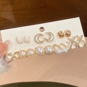 Dettaglio del set di orecchini a lobo con fiori, perle, smalto e strass eleganti