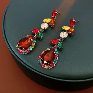 Detailed view of vintage-style earrings with colorful gemstones and leaf drop design