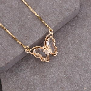 18K gold plated necklace with transparent crystal butterfly pendant on a grey stone