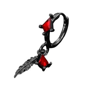 Detail of black gothic feather earring featuring red gemstone and intricate metal texture