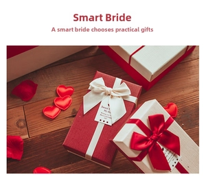 Close-up of elegant wedding gift boxes with silk bows and tags on a wooden surface