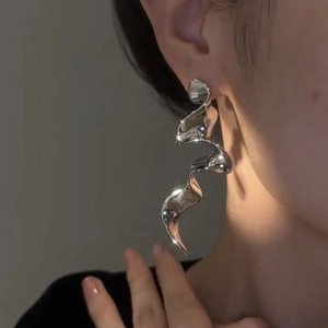 Elegant silver liquid ribbon tassel earrings with a metallic mirror finish on model