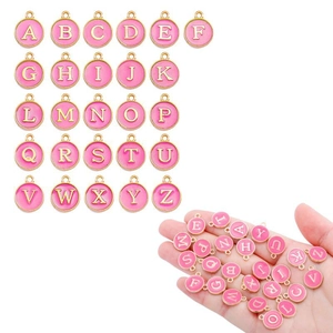 Pink enamel A-Z alphabet charms set with gold plating held by hand for size detail