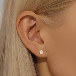 Close-up of a hexagonal gold S925 silver earring with a clear gemstone on ear