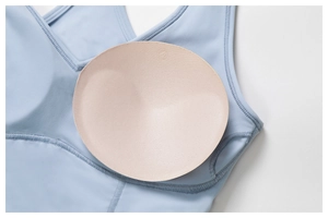 Detail of light blue yoga bra featuring removable breathable nude round padding inserts