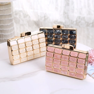 Macro detail of acrylic evening clutch bags with marble texture and gold metal frames