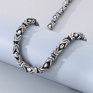 Macro shot of punk style Byzantine weave chain bracelet in vintage silver finish