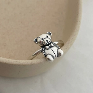 Minimalist 925 sterling silver ring featuring a vintage teddy bear pendant on ceramic edge