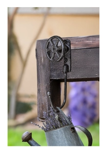 Detalle de gancho de rueda industrial de hierro fundido montado en madera maciza oscura