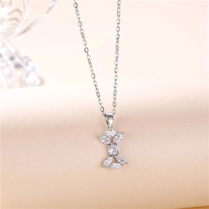 Silver bow pendant necklace with sparkling white stones on a minimalist titanium chain