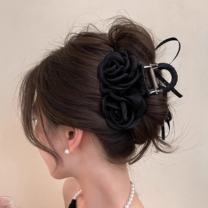 Elegant black double fabric rose hair claw clip for women shown on model hair