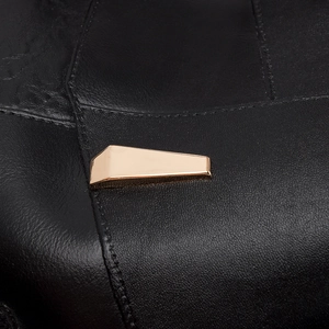Macro shot of black lychee grain leather texture and polished gold geometric metal buckle