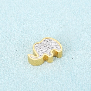 Elegant gold elephant necklace with sparkling crystals on a blue textured background