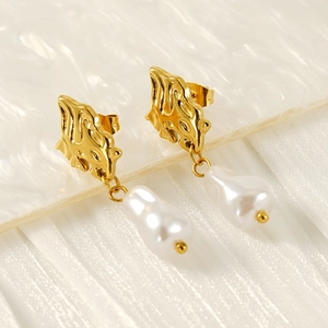 Gros plan de boucles d'oreilles en perles baroques avec métal doré et lustre élégant