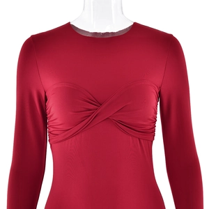 Détail d'une robe moulante rouge foncé avec nœud torsadé chic et design plissé devant