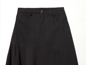Detail des schwarzen Midirocks mit asymmetrischer Taillennaht und Einzelknopfverschluss