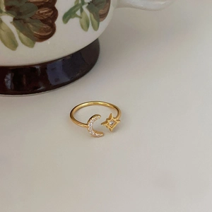 Macro detail of gold adjustable ring featuring pave moon and star with zircon accents