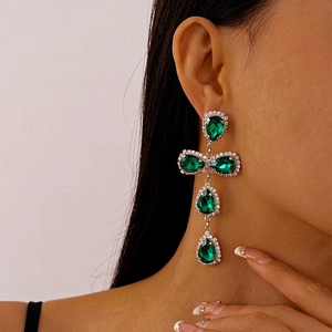 Close-up of elegant green teardrop tassel earrings worn by a model in a side profile